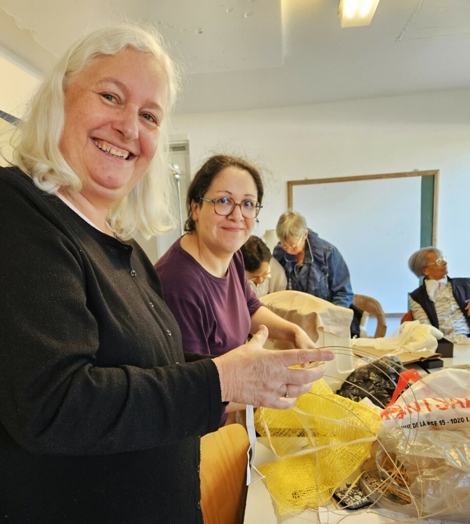 Participantes de l’atelier de modélisme et patronage travaillant ensemble sur des projets textiles dans une ambiance conviviale et créative.