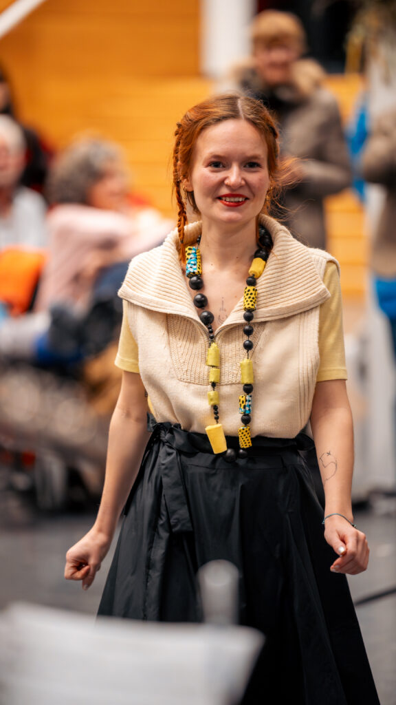 Participante présentant une création textile réalisée dans le cadre de l’atelier de stylisme et créations textiles upcycling.